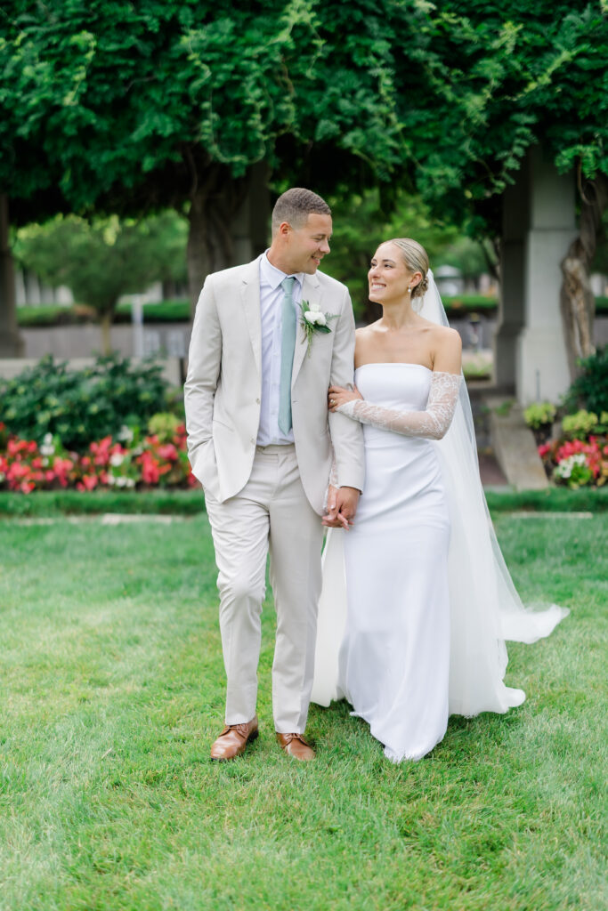 Bride and groom sharing kiss under lush greenery arch in Covington KY garden.