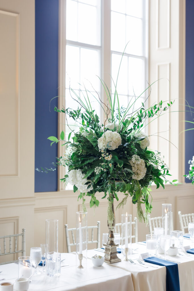 Elegant Grand Ballroom wedding reception with navy table runners, silver chairs, and candlelit centerpieces in Covington KY.
