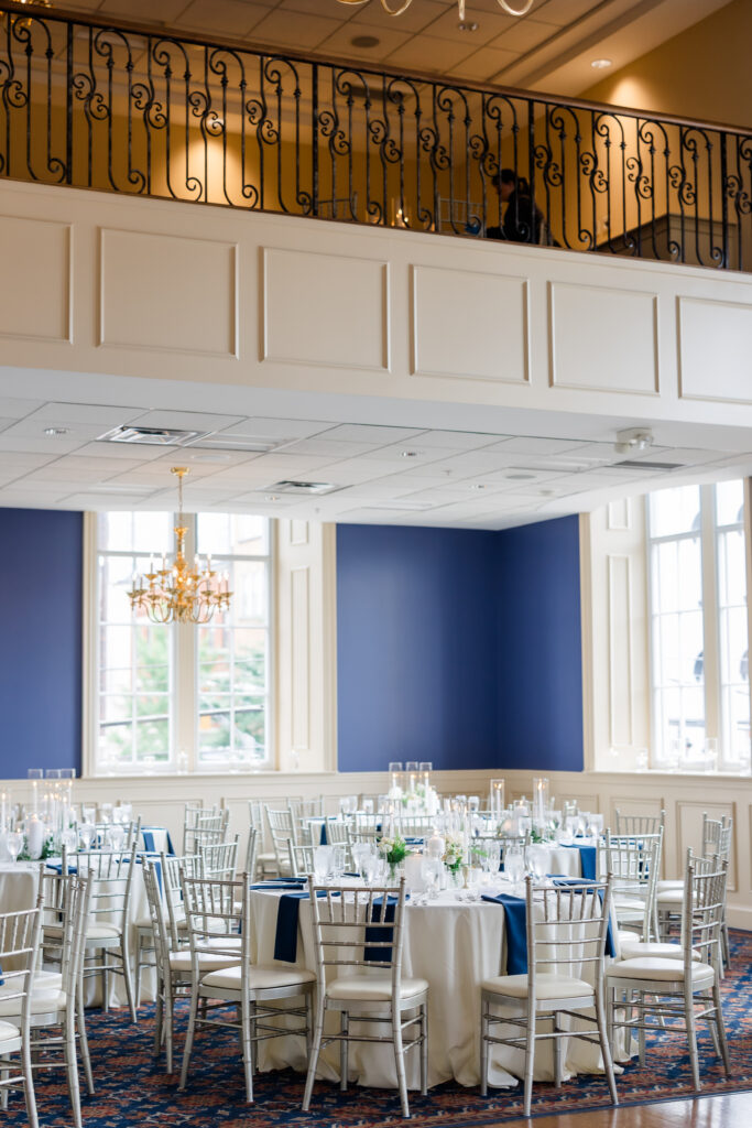 Elegant Grand Ballroom wedding reception with navy table runners, silver chairs, and candlelit centerpieces in Covington KY.