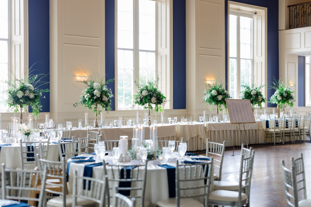 Elegant Grand Ballroom wedding reception with navy table runners, silver chairs, and candlelit centerpieces in Covington KY.