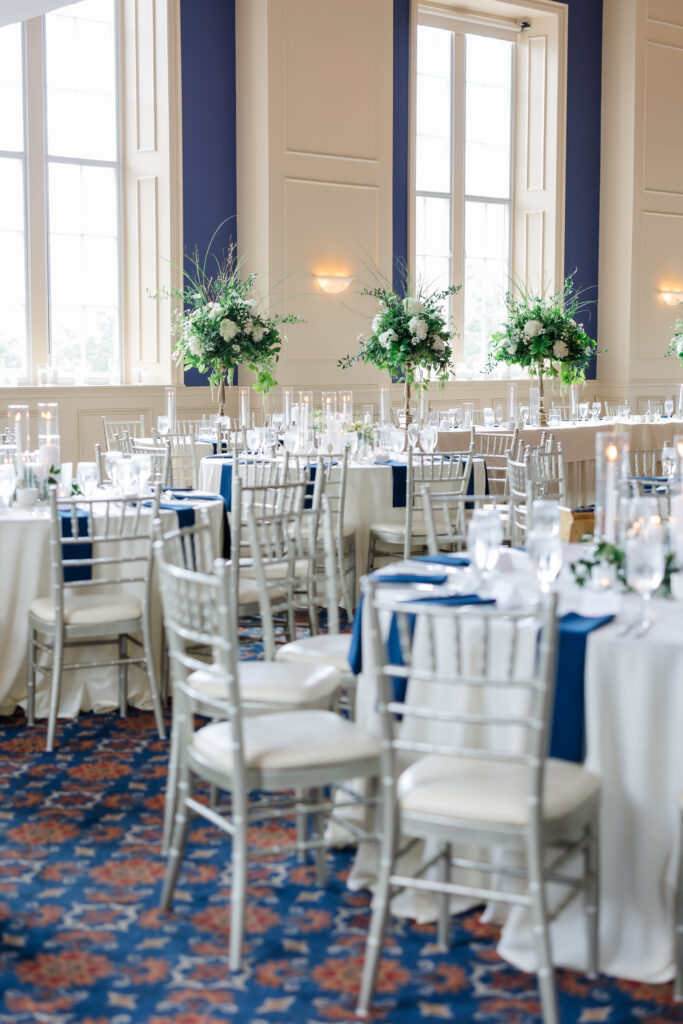 Elegant Grand Ballroom wedding reception with navy table runners, silver chairs, and candlelit centerpieces in Covington KY.